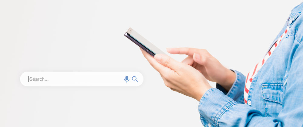 Somebody uses a smartphone whilst a visual of a search bar appears on screen